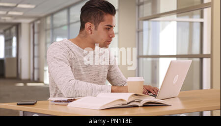 Tausendjährige Latino Studenten im Wohnheim Arbeiten am Laptop Stockfoto