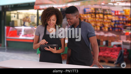 Schwarze männliche und weibliche Kellner mit digitalen Tablet an der London Street Market Stockfoto