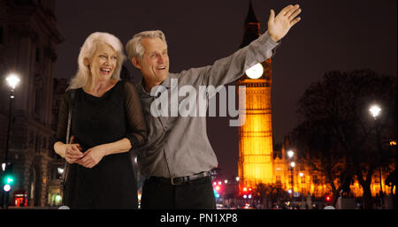 Lächelnd reifes Paar ein Taxi in London bei Nacht Stockfoto