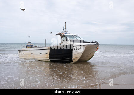 Fischer an Land in ihrem Boot auf den Strand bei Cromer, Norfolk, Großbritannien Stockfoto