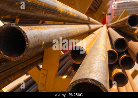 Rostiges Metall Walzstahl in einem Rack im Freien auf einem hellen, sonnigen Tag liegt. Stockfoto