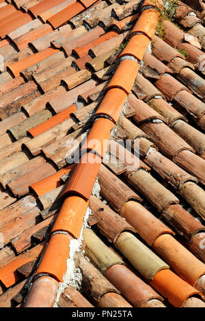 Ein Teil der Ziegel auf dem Dach eines Hauses Gebäude, Nahaufnahme. Einen roten Fliesen Terracotta Dach. Die orange Dachziegel, Maps und Texturen. Textur von Fliesen. Stockfoto