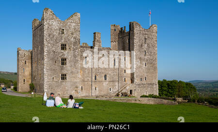 Die Leute sitzen & Picknick unter blauem Himmel durch historische mittelalterliche Burg in der wunderschönen Landschaft - Bolton Castle, Wensleydale, North Yorkshire, England, Grossbritannien Stockfoto