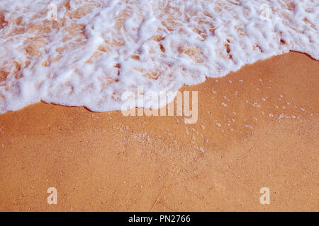 Küste. Meer Wellen mit weißen Schaum laufen auf Sandstrand. Stockfoto