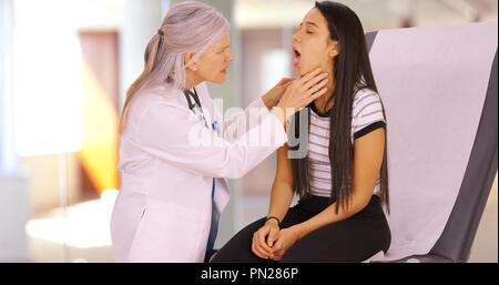 Ein älterer Arzt gibt ein Mädchen einen jährlichen Check-up Stockfoto