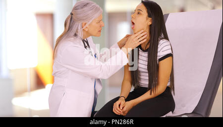 Ein älterer Arzt gibt ein Mädchen einen jährlichen Check-up Stockfoto