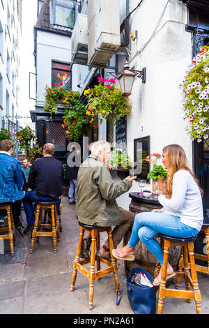 Menschen sitzen vor einem Pub auf Barhockern (die Mayflower, Rotherhithe, London, UK) Stockfoto