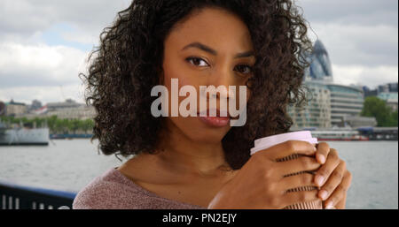 Schließen Sie die schwarze Frau touristische Holding Papier Kaffeetasse in London Stockfoto