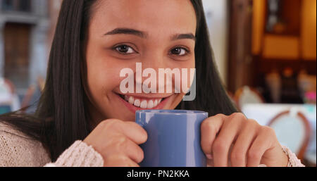 Lächelnd Latina geniesst den Duft von Kaffee in einem Cafe Stockfoto