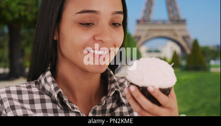 Schöne Hispanic Frau genießt eine köstliche Kuchen in Paris in der Nähe von Eiffelturm Stockfoto