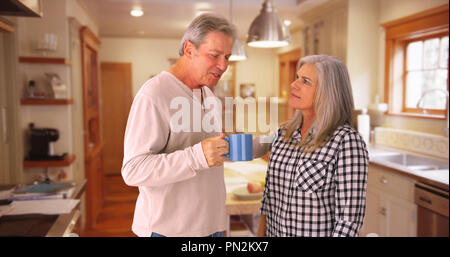 Schönen kaukasischen senior Paar stehen in Haus Küche sprechen Stockfoto