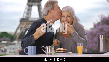Ältere weiße männliche und weibliche in der Nähe von Eiffelturm Essen leckeres Frühstück Gebäck Stockfoto