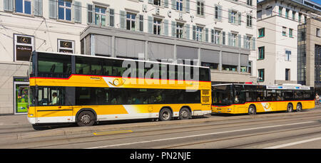 St. Gallen, Schweiz - 19. September 2018: zwei PostAuto Busse auf dem Marktplatz in der Stadt St. Gallen. PostAuto Schweiz ist eine Tochtergesellschaft der Co Stockfoto