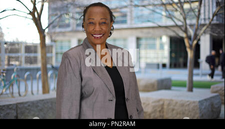 Reifen schwarz Geschäftsfrau stellt für Portrait an außerhalb Business Park Stockfoto