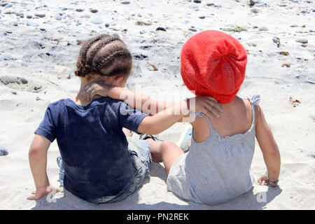 Zwei Kleinkinder im sand sitzen Stockfoto