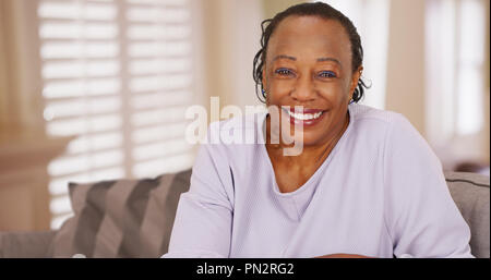 Eine ältere schwarze Frau sieht glücklich in die Kamera Stockfoto