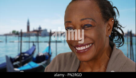 Gerne reife schwarze Frau, die durch den Canale Grande zu lächeln und zu lachen Stockfoto