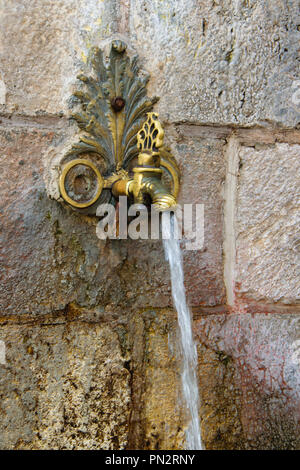 Antike schmiedeeiserne, aus dem Wasserhahn fließt Stockfoto