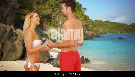 Tausendjährige Paar in Liebe Hände halten und Unterhaltung am Strand Stockfoto