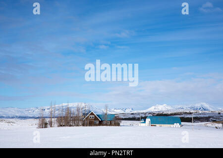 Malerische Farm und Homestead in verschneiter Landschaft in Island Stockfoto