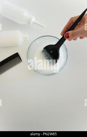 Blick von oben auf die Frau Anmischen von Hand Haarfärbemittel Farbe und Färbung Haare Produkte auf weißem Hintergrund, Platz für Text Stockfoto