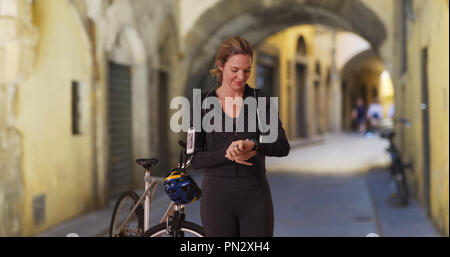 Frau in Florenz ruhen von Bike mit Fitness tracker Fahrt Stockfoto
