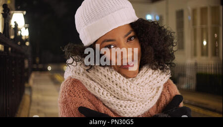 Gerne afrikanische amerikanische Frau, die versucht, warm auf kalt Winter Nacht in der Stadt zu halten. Stockfoto