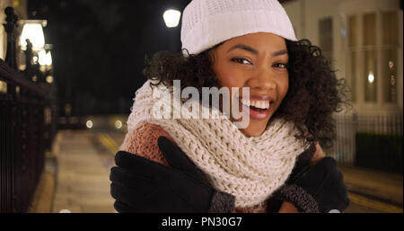 Gerne afrikanische amerikanische Frau, die versucht, warm auf kalt Winter Nacht in der Stadt zu halten. Stockfoto