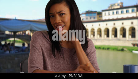 Schwarze Frau im Urlaub in Florenz Videoanrufe Arzt über Nackenschmerzen Stockfoto