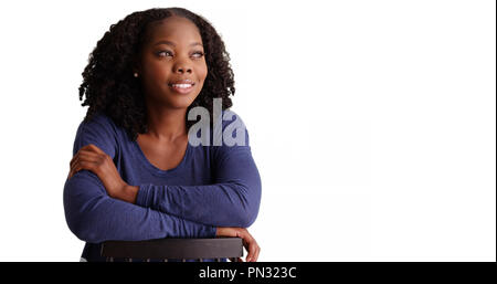 Portrait von schwarze Frau rückwärts sitzen im Stuhl auf weißem Hintergrund Stockfoto