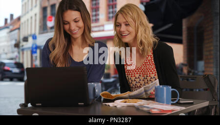 Schöne blonde Frau mit Freundin mit Laptop im Cafe in Brügge Belgien Stockfoto
