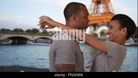 Ausschreibung afrikanischen Paar Umarmung durch Seine River in der Nähe von Eiffelturm Stockfoto