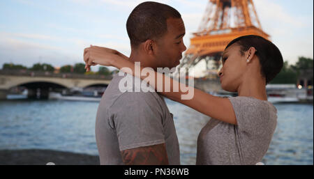 Ausschreibung afrikanischen Paar Umarmung durch Seine River in der Nähe von Eiffelturm Stockfoto
