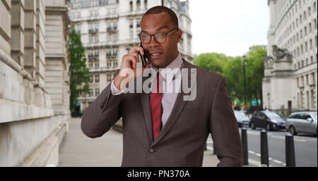 Moderne Afro-amerikanische Geschäftsmann in London im Gespräch mit Kunden am Telefon Stockfoto