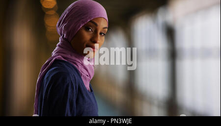 Eine attraktive junge muslimische Frau dreht sich zu lächeln an Kamera Stockfoto
