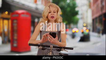 Ziemlich Radfahrer in London England Kontrollen Mobiltelefon für Richtungen Stockfoto