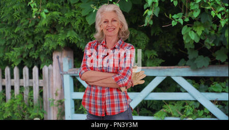 Reife Frau in Rot Flanellhemd nimmt eine Pause von der Arbeit auf dem Bauernhof Stockfoto