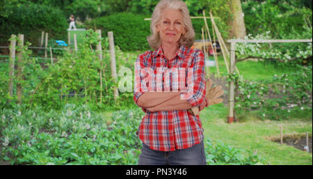 Reifen kaukasische Frau in pflanzlichen oder Kräutergarten mit ihrer Arbeit glücklich lächelnde Stockfoto