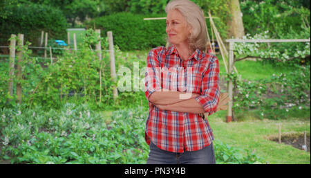 Reifen kaukasische Frau in pflanzlichen oder Kräutergarten mit ihrer Arbeit glücklich lächelnde Stockfoto