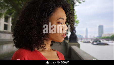 Nachdenklich, afrikanische Frau aus den Blick in die Ferne durch die Themse in London. Stockfoto