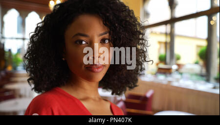 Junge schwarze Lady tief in Gedanken die Kamera im Restaurant Einstellung Stockfoto