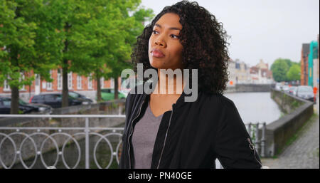 Attraktive afrikanische amerikanische Frau im Urlaub stand neben Canal in Brügge Stockfoto