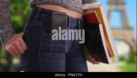 In der Nähe des College Mädchen, die Bücher mit Telefon in der Tasche von Eiffelturm Stockfoto