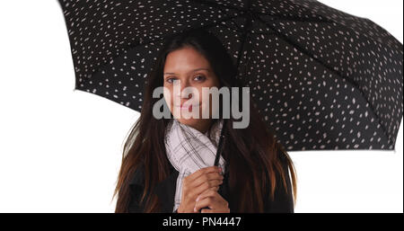 Schöne Frau mit gepunkteten Regenschirm lächelnd auf weißem Hintergrund Stockfoto