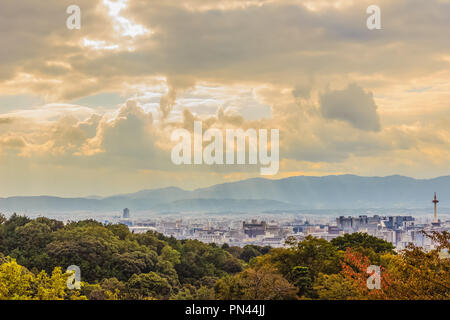 Sonnenstrahlen durch die Wolken über die Stadt Kyoto, Japan scheint. Aus Sicht der Stadt Kyoto Kiyomizu Tempel mit dramatischen bewölkten Himmel und Sonne strahlen auf b Stockfoto