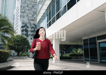 Geschäftsfrau Gespräch am Handy und Pendeln Stockfoto