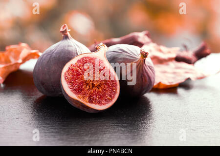 Nahaufnahme auf frische Feigen auf dunklen glänzenden Stein Platte draussen, getönten Bild Stockfoto