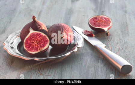 Frische Früchte - Feigen der Metallplatte mit Messer auf dem hölzernen Tisch Stockfoto
