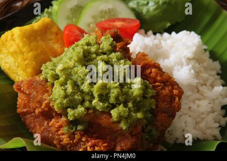 Ayam Geprek Andaliman. Fusion Street Food Gericht der Southern Fried Chicken gekrönt mit Sambal Andaliman, die grüne Chili und Andaliman Pfeffersoße. Stockfoto