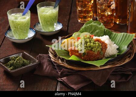 Ayam Geprek Andaliman. Fusion Street Food Gericht der Southern Fried Chicken gekrönt mit Sambal Andaliman, die grüne Chili und Andaliman Pfeffersoße. Stockfoto